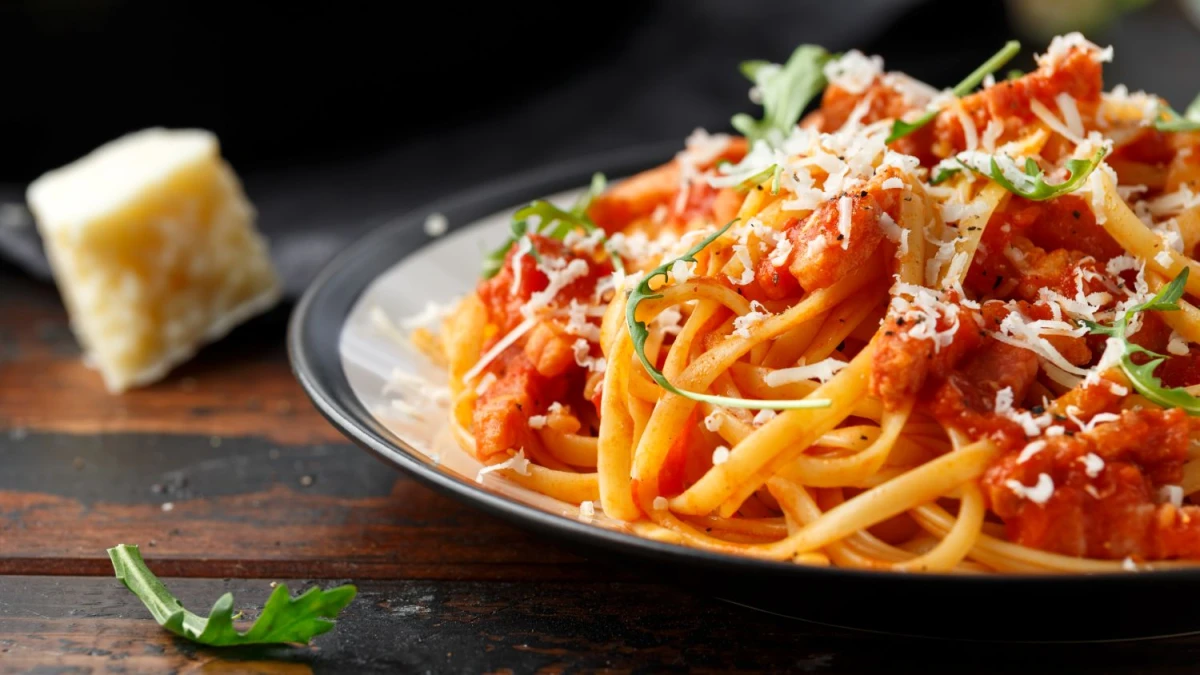 Spaghetti z tuńczykiem w sosie pomidorowym podane na czarnym talerzu